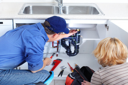 affordable plumber fixing a sink at home kitchen