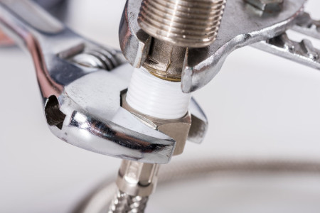 technician screwing plumbing fittings